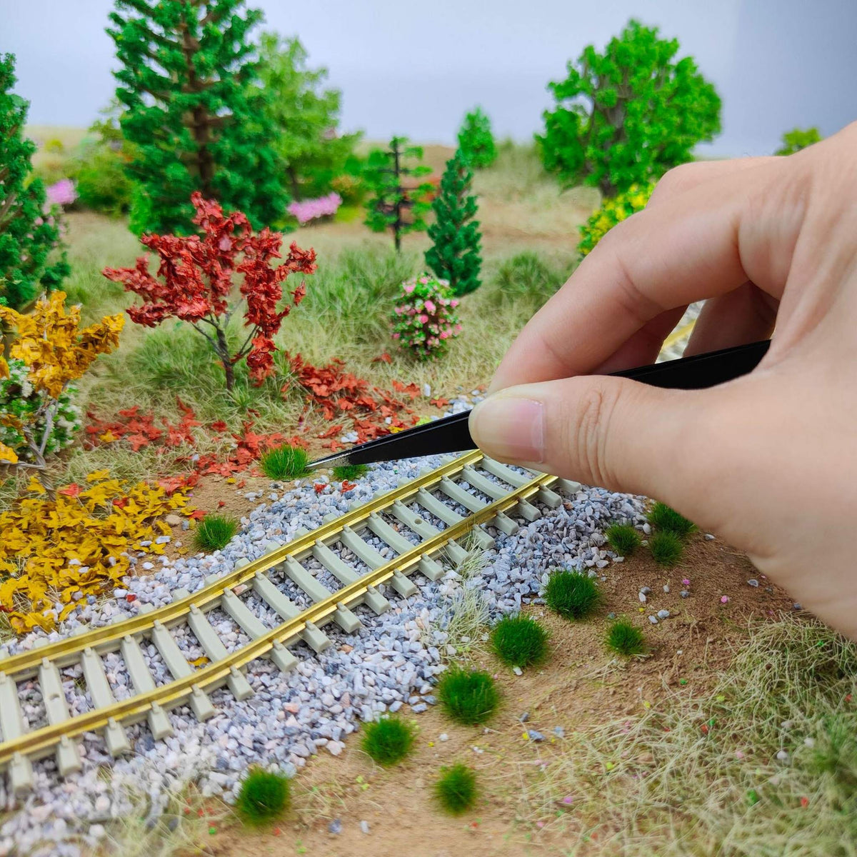 Peeling 5mm grass tufts off the backing film with tweezers - Wargame Base World