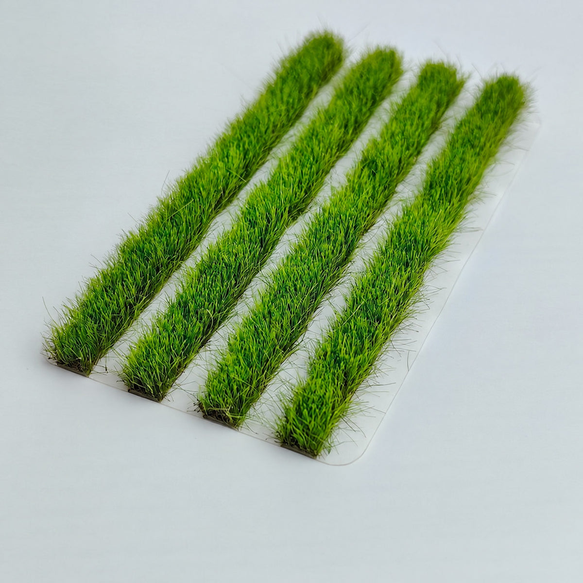 Four green 8mm strip grass tufts on white background - Wargame Base World